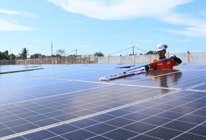 Petugas PLTS PLN Batam di Tanjunguma, tengah membersihkan panel surya.