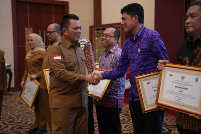 Gubernur Provinsi Kepulauan Riau, Ansar Ahmad menyerahkan penghargaan Paritrana Award Tingkat Provinsi Kepulauan Riau kepada PLN Batam yang diwakili Sekretaris Perusahaan PT PLN Batam, Samsul Bahri di Gedung Daerah Provinsi Kepri, Tanjungpinang. (Foto: diskominfo kepri)