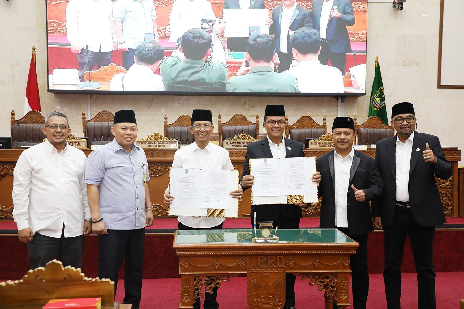 Wali Kota Batam, Amsakar Achmad, bersama pimpinan dan anggota DPRD Batam menunjukkan dokumen pengesahan Perda PSU usai Rapat Paripurna di Ruang Sidang Utama DPRD Kota Batam, Rabu (24/6/2026). HUMAS DISKOMINFO BATAM