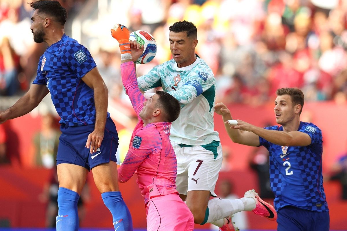 Kiper Timnas Kroasia, Dominik Livakovic, menendang bola menjauh di samping penyerang Portugal, Cristiano Ronaldo, dalam pertandingan babak 32 besar Piala Dunia 2026 antara Portugal dan Kroasia di Stadion Toronto, Toronto, pada Jumat (3/7/2026) pagi WIB.(COLE BURSTON/AFP)